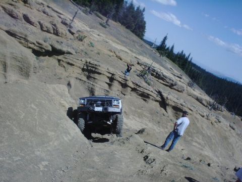1978 Ford Bronco - A modified truck navigates a challenging off-road trail on a steep mountainside.