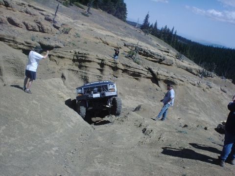 1978 Ford Bronco - A 1978 Ford Bronco navigates a challenging off-road trail on a sunny day.