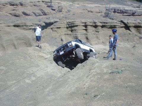 1978 Ford Bronco - A 1978 Ford Bronco navigates a steep dirt hill with onlookers observing the off-road maneuver.