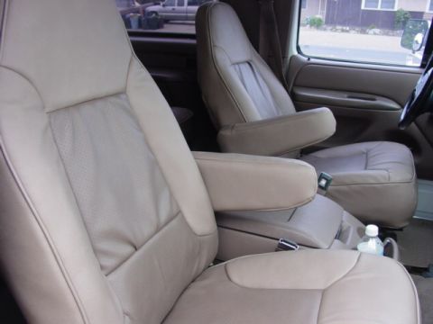 1992 Ford Bronco - Interior view of tan leather bucket seats with armrests, showing perforated seat inserts and a center console.