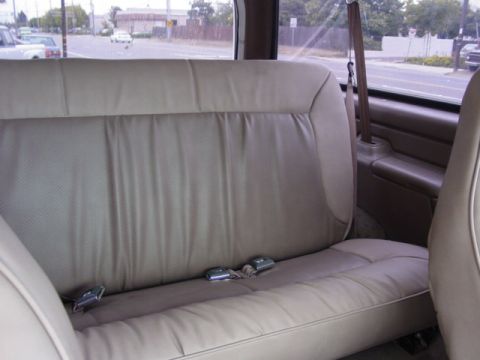 1992 Ford Bronco - Interior view of a tan bench seat with seatbelts in a 1992 Ford Bronco.