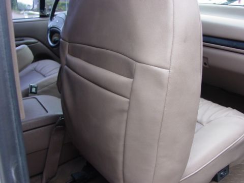 1992 Ford Bronco - Interior view of a 1992 Ford Bronco, focusing on the tan bench seat and dashboard details.