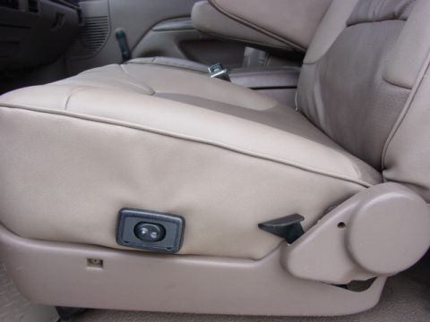 1992 Ford Bronco - The interior of a vehicle shows tan leather seats with visible power adjustment controls on the side of the driver's seat.