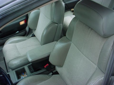 1973 Ford Ranchero - The interior of a car features two-tone bucket seats and a center console with an armrest and coin holder.