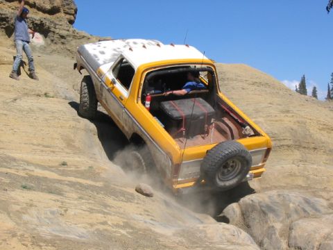 1995 Ford Bronco - This vintage SUV navigates a challenging off-road course, kicking up dust as it climbs.