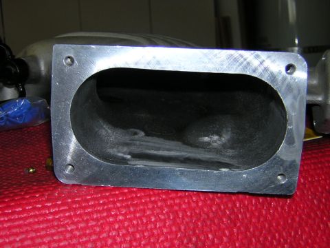 1992 Ford Crown Victoria - A close-up view of an intake manifold part, showing its machined aluminum opening and internal structure.
