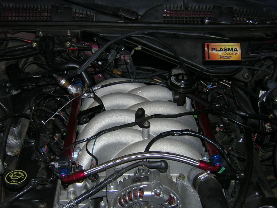 Engine bay showing intake manifold, wiring, and a "PLASMA booster" sticker