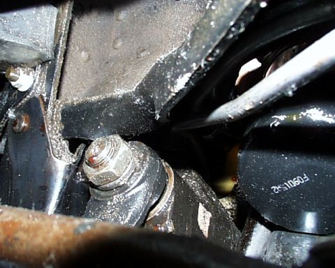1988 Ford C-350 (Centurion Conversions) - A close-up view of an engine oil filter and its mounting bracket, showing some wear and tear.