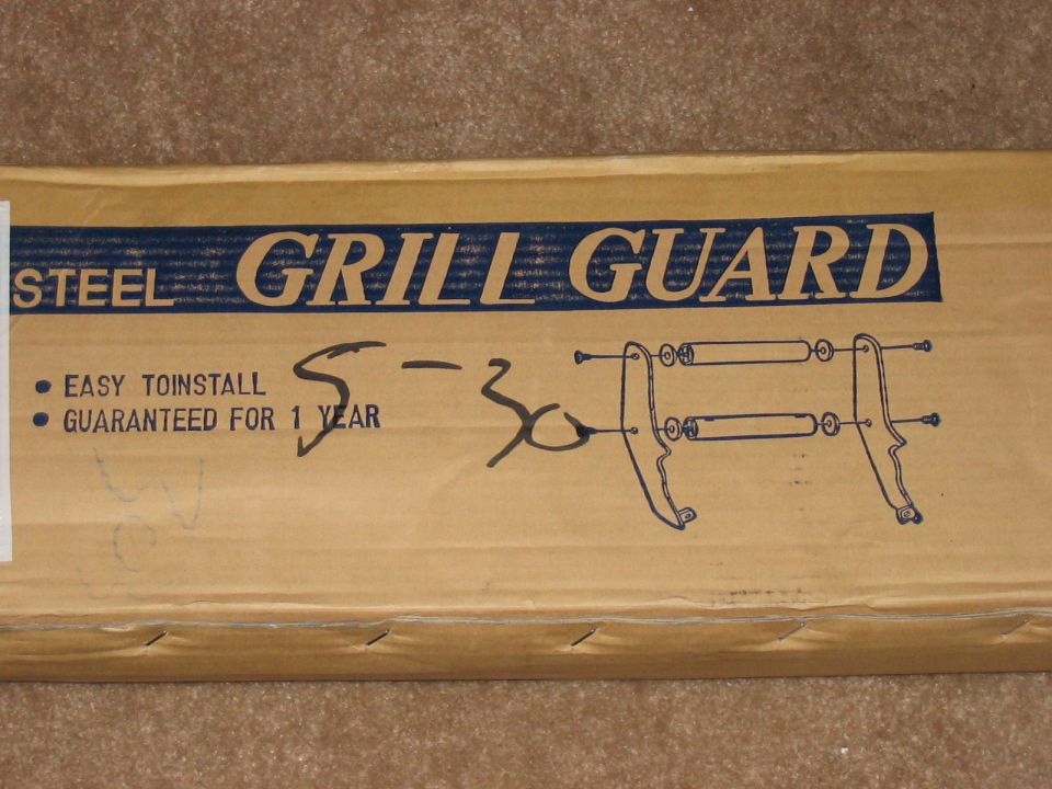 Cardboard box labeled "STEEL GRILL GUARD" with installation diagram and "EASY TOINSTALL GUARANTEED FOR 1 YEAR" text