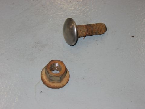 1988 Ford Bronco - A rusty bolt and a matching nut are shown on a gray surface, with the Supermotors.net logo in the corner.