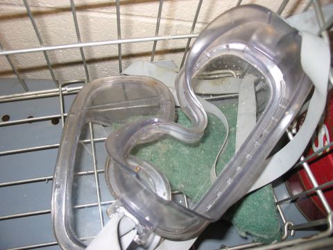 1988 Ford Bronco - A pair of goggles rests in a wire basket, with a green scrub pad visible beneath them.