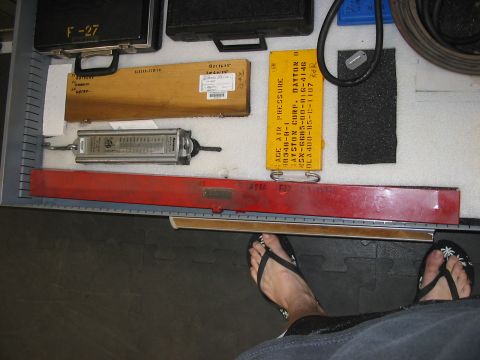 1988 Ford Bronco - A collection of tools and equipment is organized within a drawer, with a person's feet in flip-flops in the foreground.
