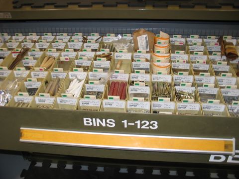 1988 Ford Bronco - Organized bins containing various hardware and small parts are neatly arranged on a shelf.