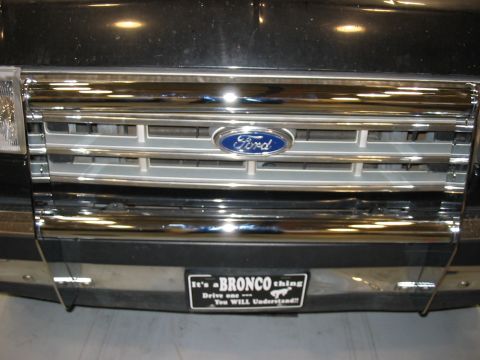 1988 Ford Bronco - A close-up of a Ford Bronco's front grille and bumper, a novelty plate that playfully suggests the unique experience of driving one.