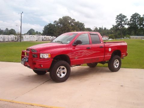 1980 Ford Bronco - A red pickup truck with custom decals is parked outdoors on a paved surface.
