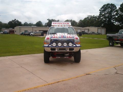 1980 Ford Bronco - A modified truck with "SkyJacker" branding is parked outside a building.