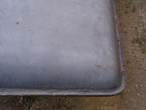 1967 Ford Bronco - Close-up view of a dark gray hardtop, showing some surface wear and rust along the edge.