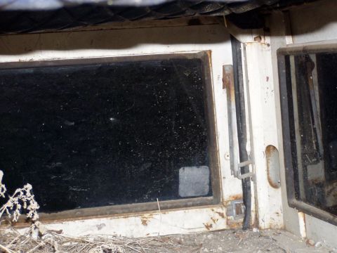 1967 Ford Bronco - Detail of a vehicle's door frame and window, showing wear and tear.
