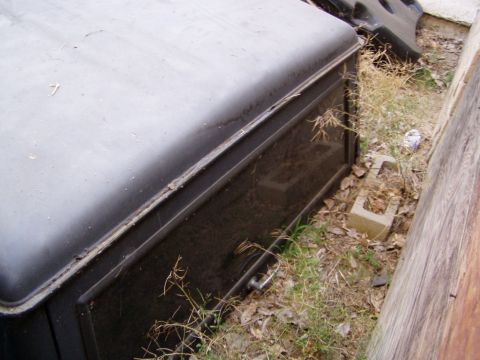 1967 Ford Bronco - A black storage box with a handle is shown outdoors, partially obscured by dry vegetation.
