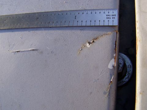 1967 Ford Bronco - Detail of a damaged metal panel, showing rust and surface imperfections, with a ruler for scale.