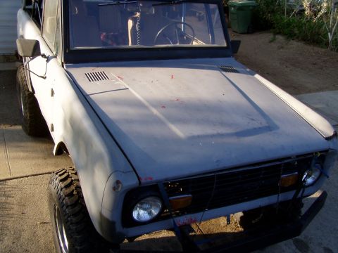 1967 Ford Bronco - This is a front-side view of a dusty gray Ford Bronco, showing its hood and tires.