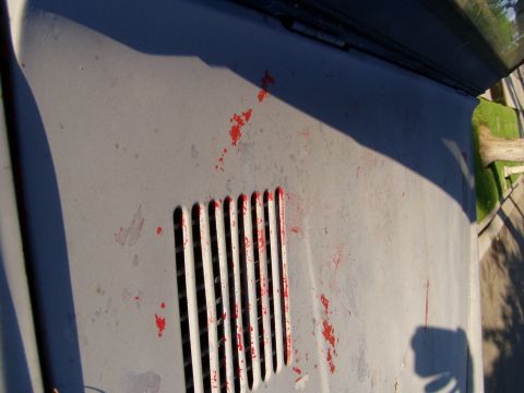 1967 Ford Bronco - Close-up of a vehicle's hood vent, showing chipped red paint and a watermark.