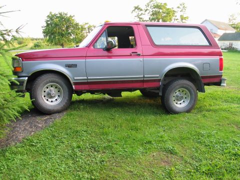 1995 Ford Bronco - Side profile of a 1995 Ford Bronco with two-tone red and silver paint.