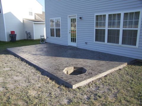 1995 Ford Bronco - A backyard scene a stamped concrete patio with a hexagonal fire pit and a light blue sided house.