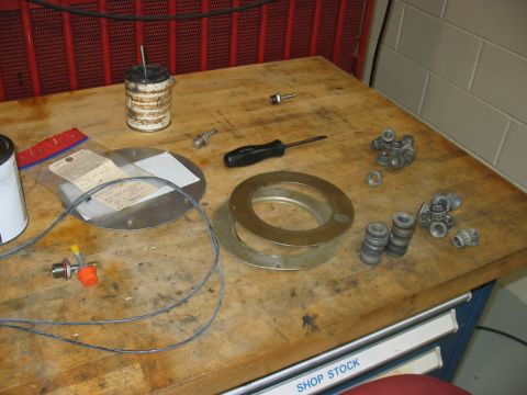 1988 Ford Bronco - Various automotive parts and tools are organized on a workbench, ready for assembly or repair.