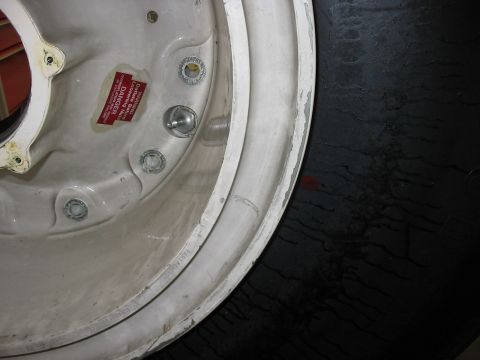 1988 Ford Bronco - Close-up view of a vehicle wheel rim, showing a DANGER sticker and lug nut mounting points.