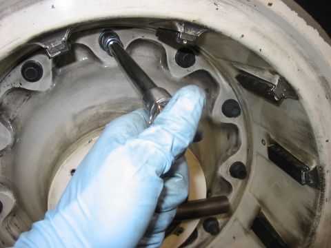 1988 Ford Bronco - A gloved hand uses a socket wrench to tighten a bolt on a vehicle's wheel hub assembly, with the Supermotors.net logo visible.