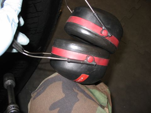1988 Ford Bronco - Ear protection is shown next to a tire, with a socket wrench visible in the lower left corner.