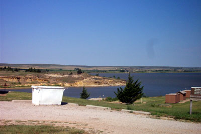 1995 Ford Bronco - A wide view of a lake and surrounding landscape under a clear blue sky, with a dumpster in the foreground.
