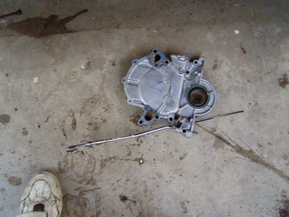 Cast-aluminum engine timing cover with crankshaft seal on a concrete floor