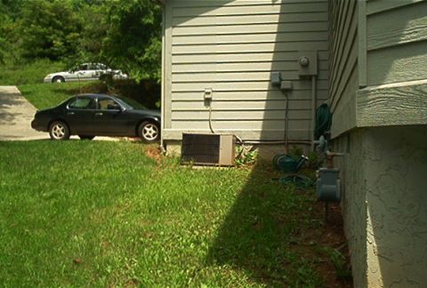 1985 Ford LTD Crown Victoria - Two sedans are visible, one dark and one white, parked in a residential area with a house in the foreground.
