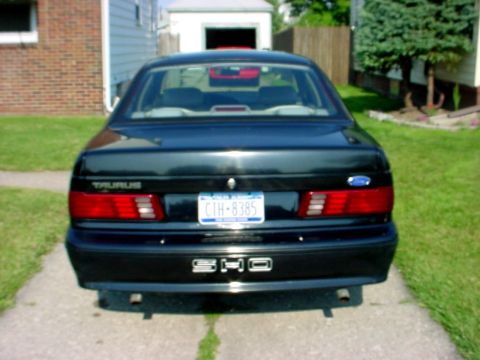 1989 Ford Taurus - Rear view of a black 1989 Ford Taurus sedan with a license plate reading CTH-8385.