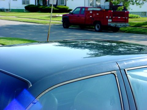 1989 Ford Taurus - A red pickup truck with a utility bed is parked on the side of a street.