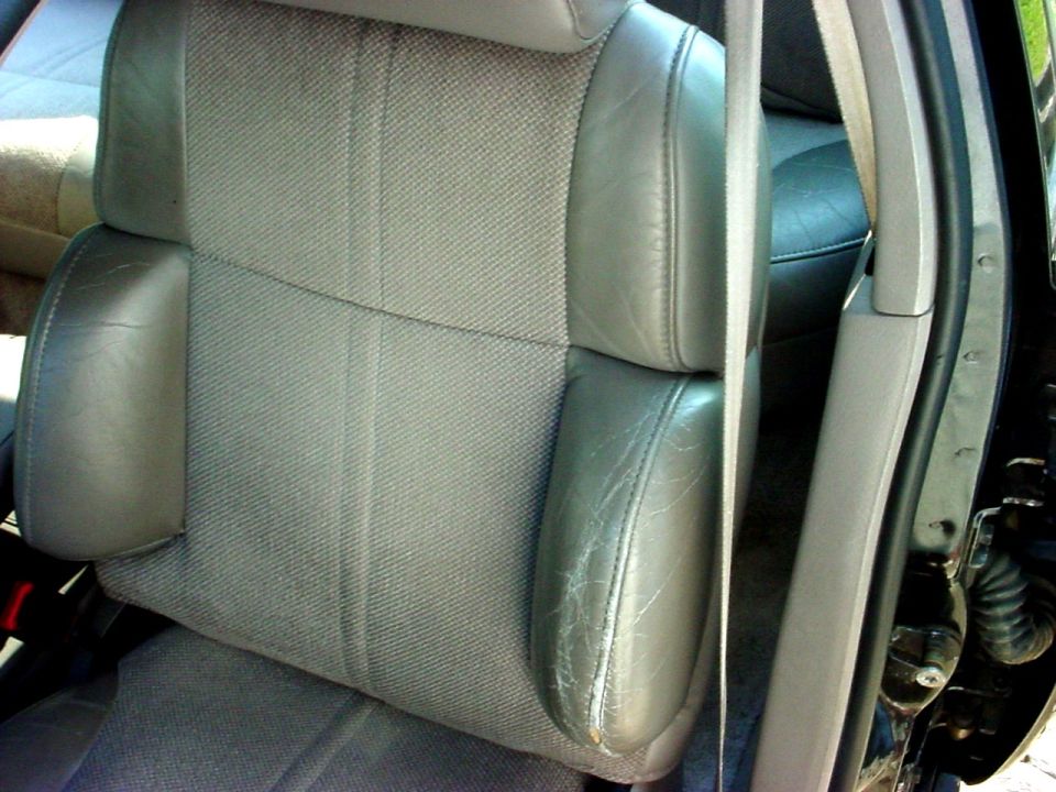 Gray fabric and leather car seat with visible wear on the leather armrest
