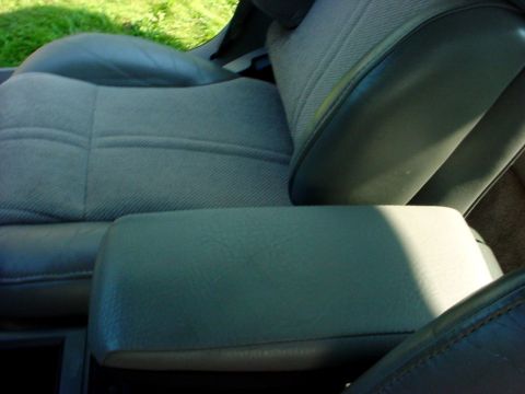 1989 Ford Taurus - Close-up of the interior showing fabric seats and a center armrest.