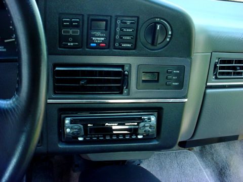 1989 Ford Taurus - Close-up of a car's dashboard, showing the climate control panel and an aftermarket stereo system.