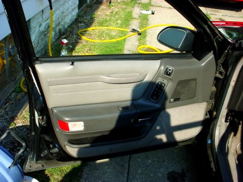 1989 Ford Taurus - Interior view of a 1989 Ford Taurus driver's side door panel, showing the armrest and controls.