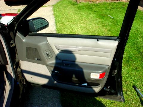 1989 Ford Taurus - The interior door panel of a car is shown with the door open to the outside.