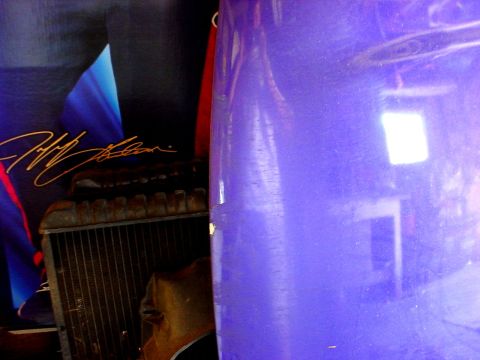 1989 Ford Taurus - Close-up of a purple car door and a radiator, with a poster in the background.