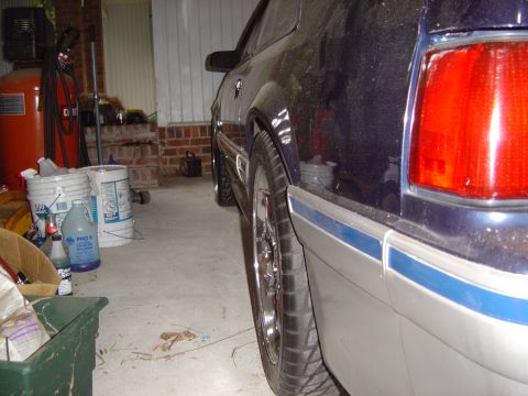 1989 Ford Mustang - Side view of a dark blue car, possibly a 1987 Ford Mustang, in a garage with various items in the background.