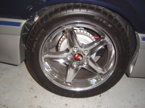 1989 Ford Mustang - Chrome wheel and tire detail, with part of the car's two-tone body visible.