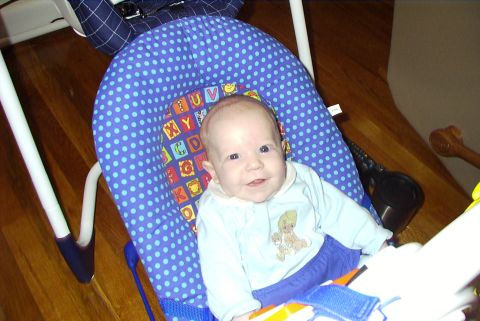 1995 Ford Bronco - A baby sits in a blue polka-dot bouncer, smiling at the camera.