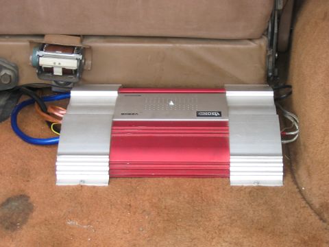 1988 Ford Bronco - A car audio amplifier is installed on the carpeted floor of a vehicle.