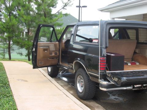 1988 Ford Bronco - This black Ford Bronco SUV is shown from the rear quarter with the driver's door ajar.