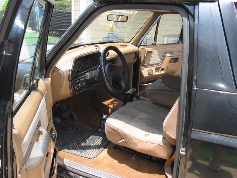 1988 Ford Bronco - The interior of a 1988 Ford Bronco features tan upholstery and a dark dashboard with visible gauges.