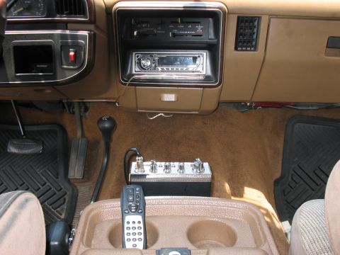 1988 Ford Bronco - The interior of the vehicle shows a CB radio mounted on the center console, along with a remote control.